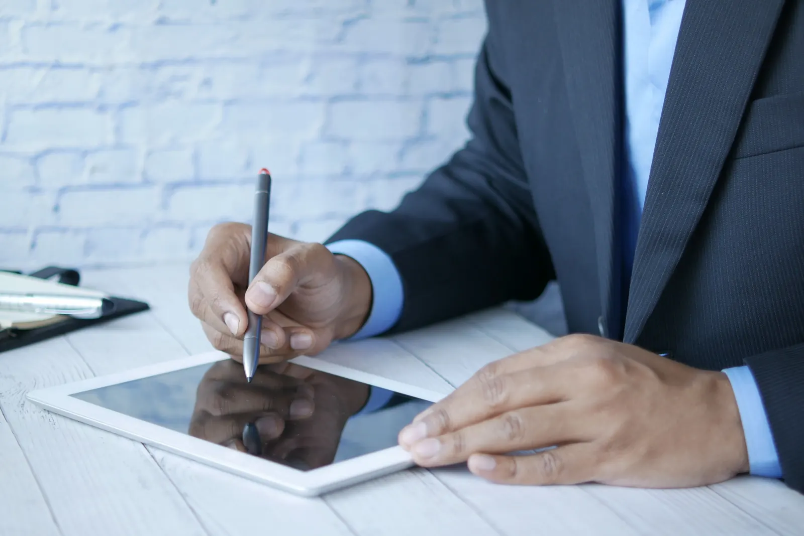 Persona firmando con lápiz óptico sobre una tablet